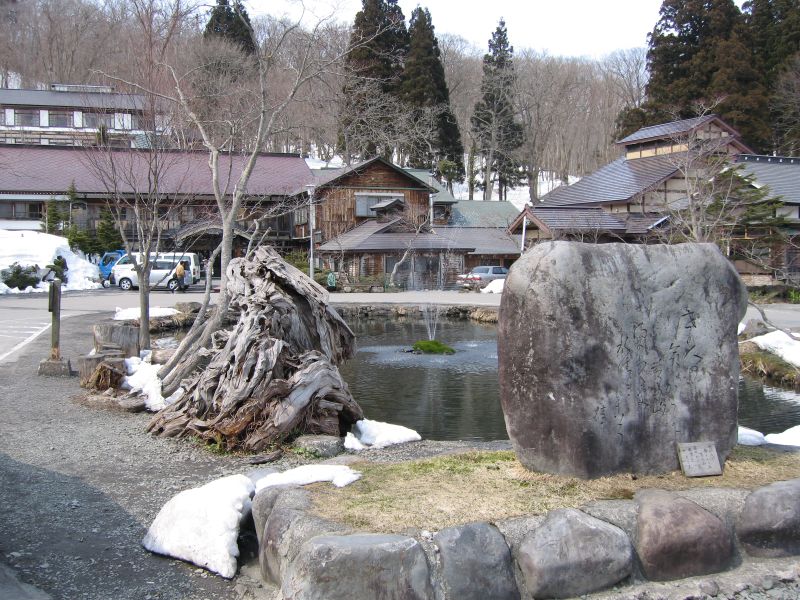 a stone sculpture is on display near a small creek