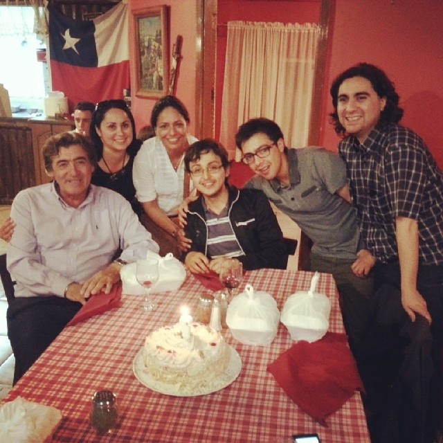 family gathered around table waiting to see birthday cake