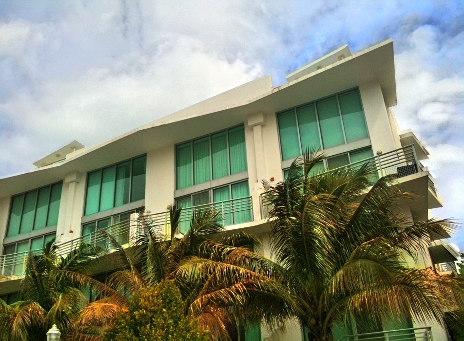 a white and green building surrounded by palm trees