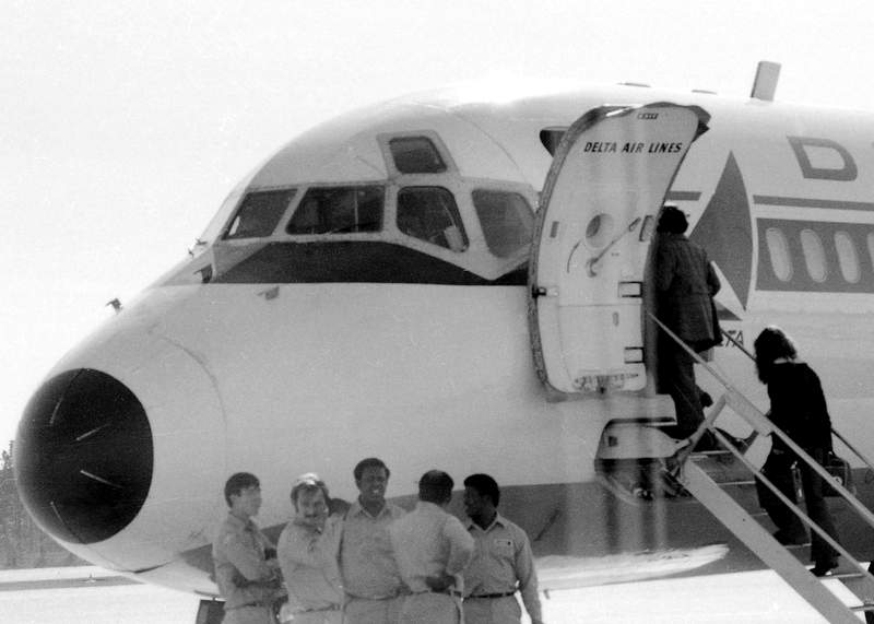 a black and white po of people boarding an airplane