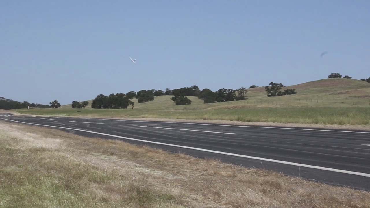 the road is empty and it looks to be going to pass through an open grassy valley