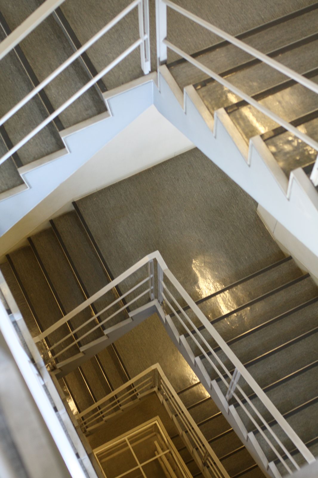 two white staircases are up against a gray wall