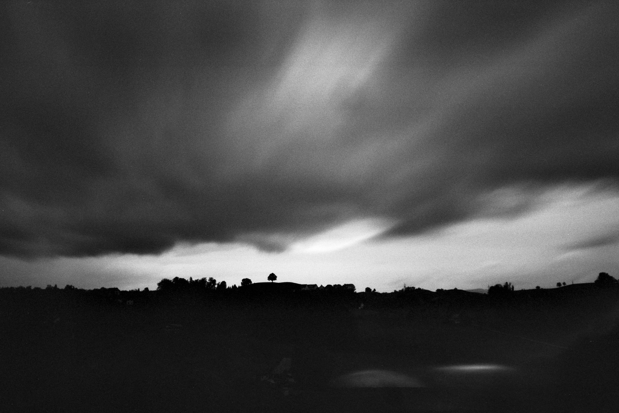 some black and white images with buildings under the clouds