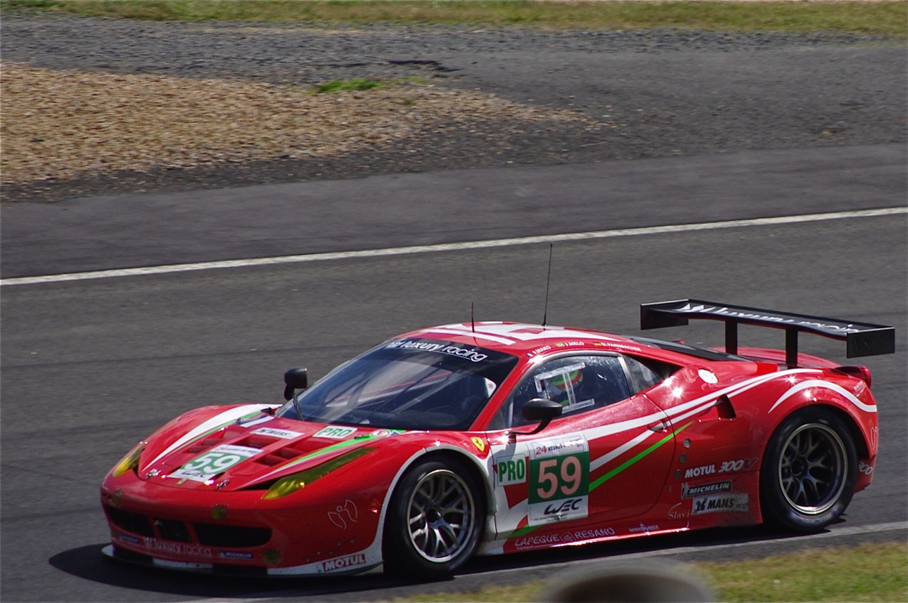 a red racing car driving around a race track