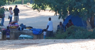 people gather around tents in an open area