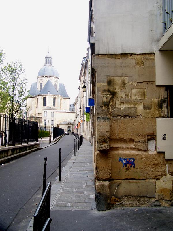 an alley with a stone building on the right