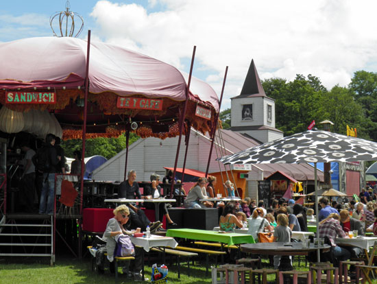 a festival with tents and tables set up in a field