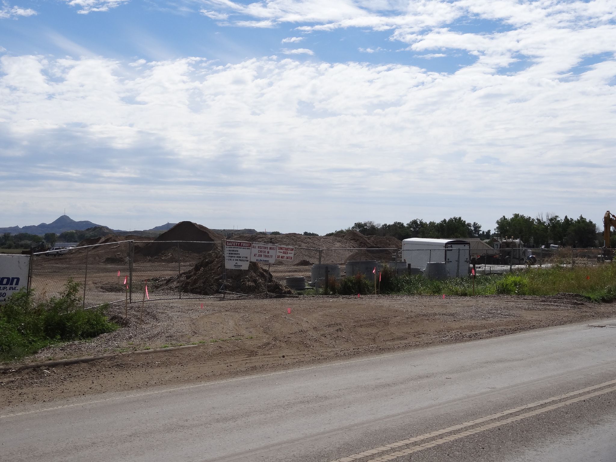 a field next to a road is full of dirt and dirt mounds