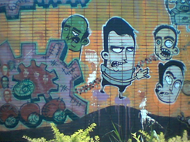 graffiti on the side of a building painted with a mural of zombies