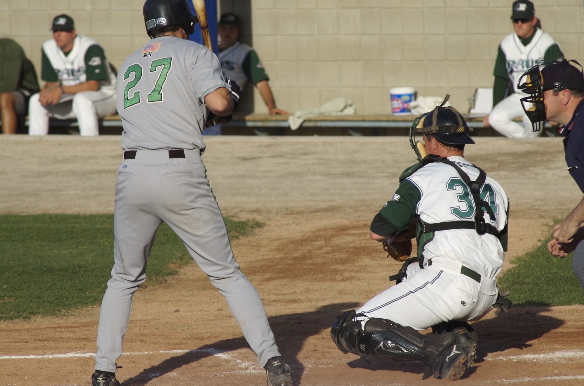 three players on a baseball field with a bat