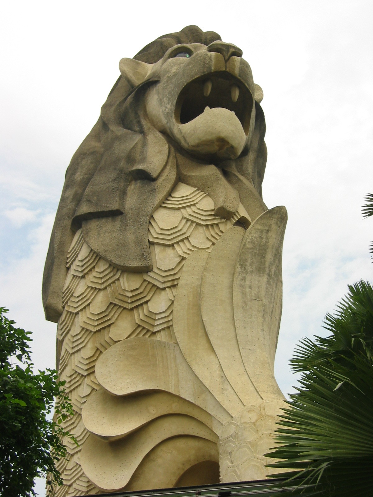 a lion statue is seen in a park setting