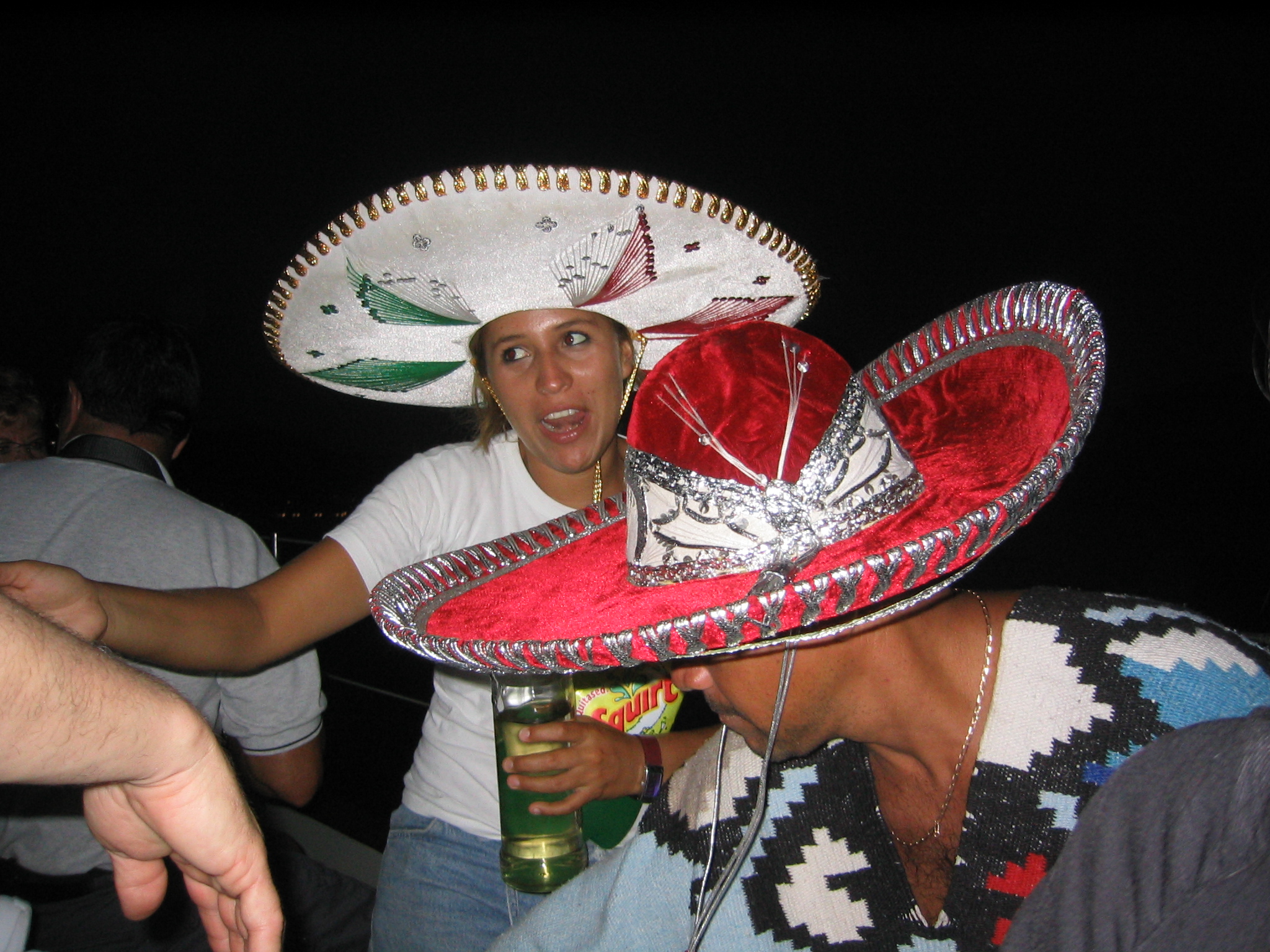 a girl in a mexican hat drinking a drink