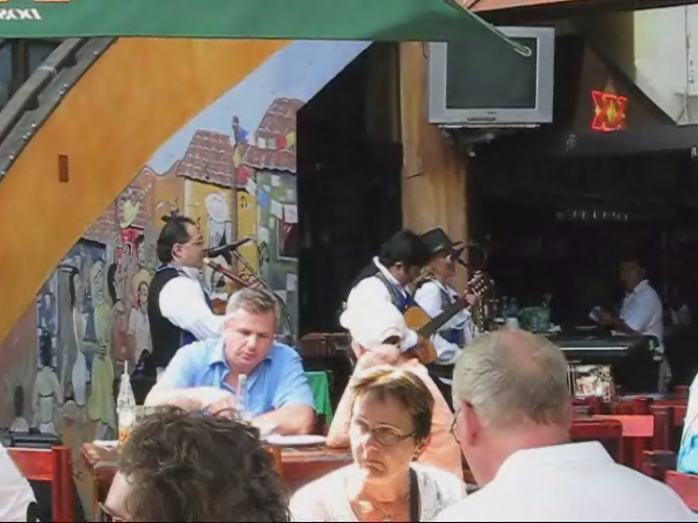people sitting in a restaurant eating food and a band