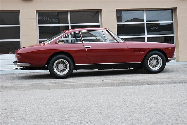 a classic car parked on the road near a building