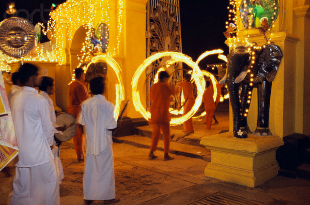 a group of people standing around in front of a statue with lights