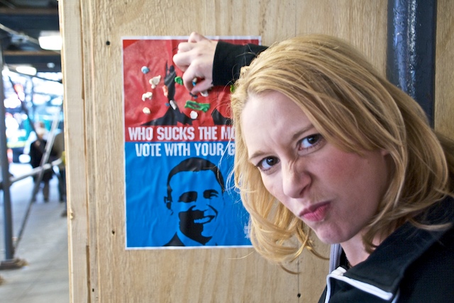 a lady posing for a po by a political poster
