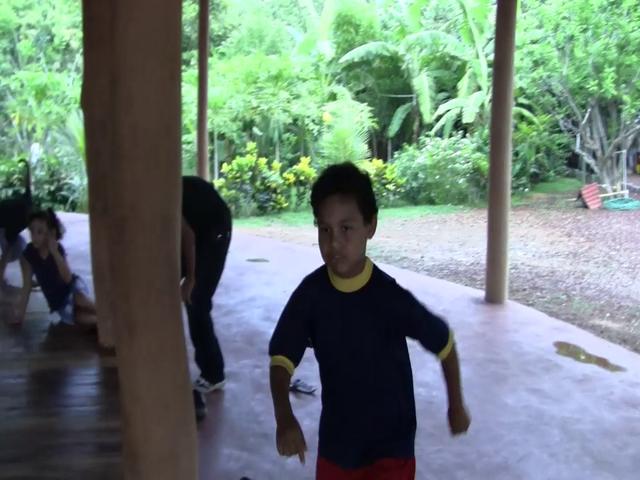the young child in blue shirt is standing on the ground