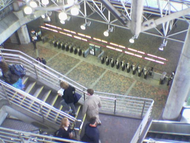 people on escalators are moving along the railings