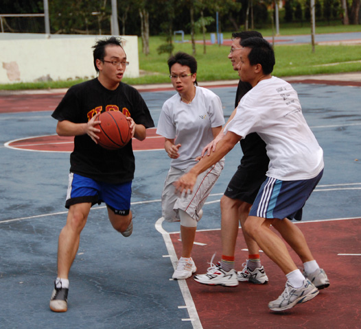 an asian basketball game in progress, with the ball in the air