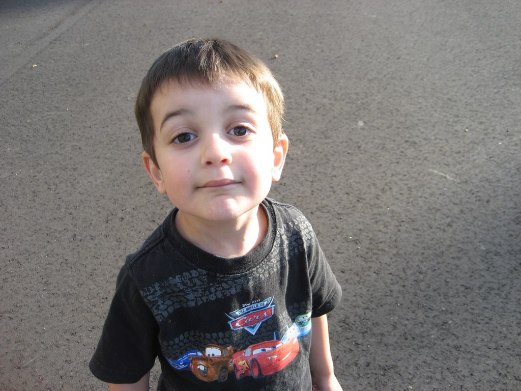 a small boy standing on a paved surface