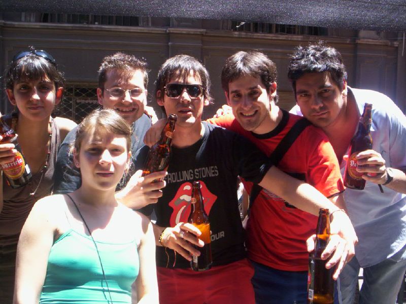 young adults standing together and holding their beer bottles