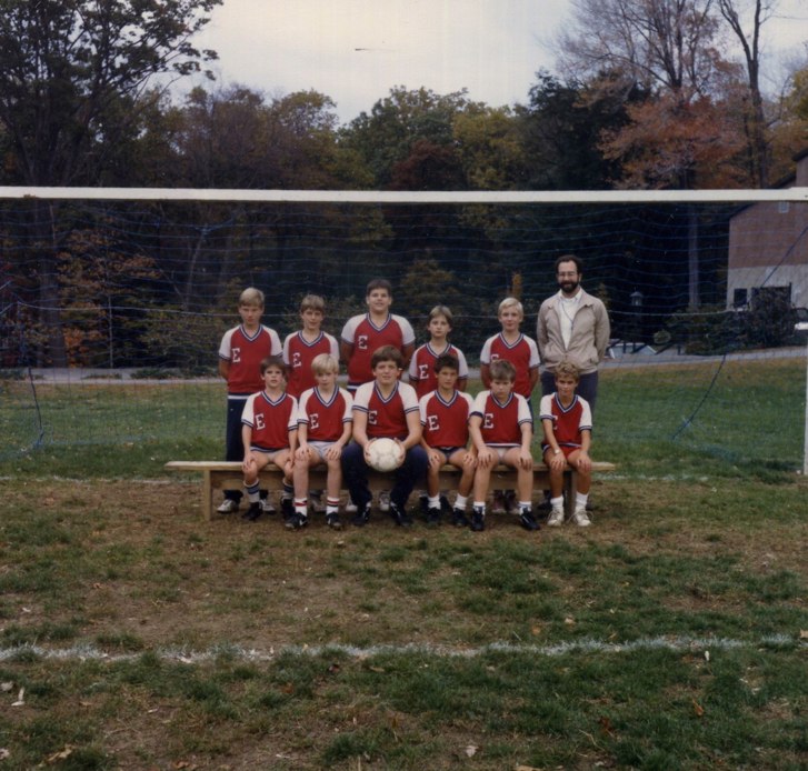 an old po of soccer team standing by the net