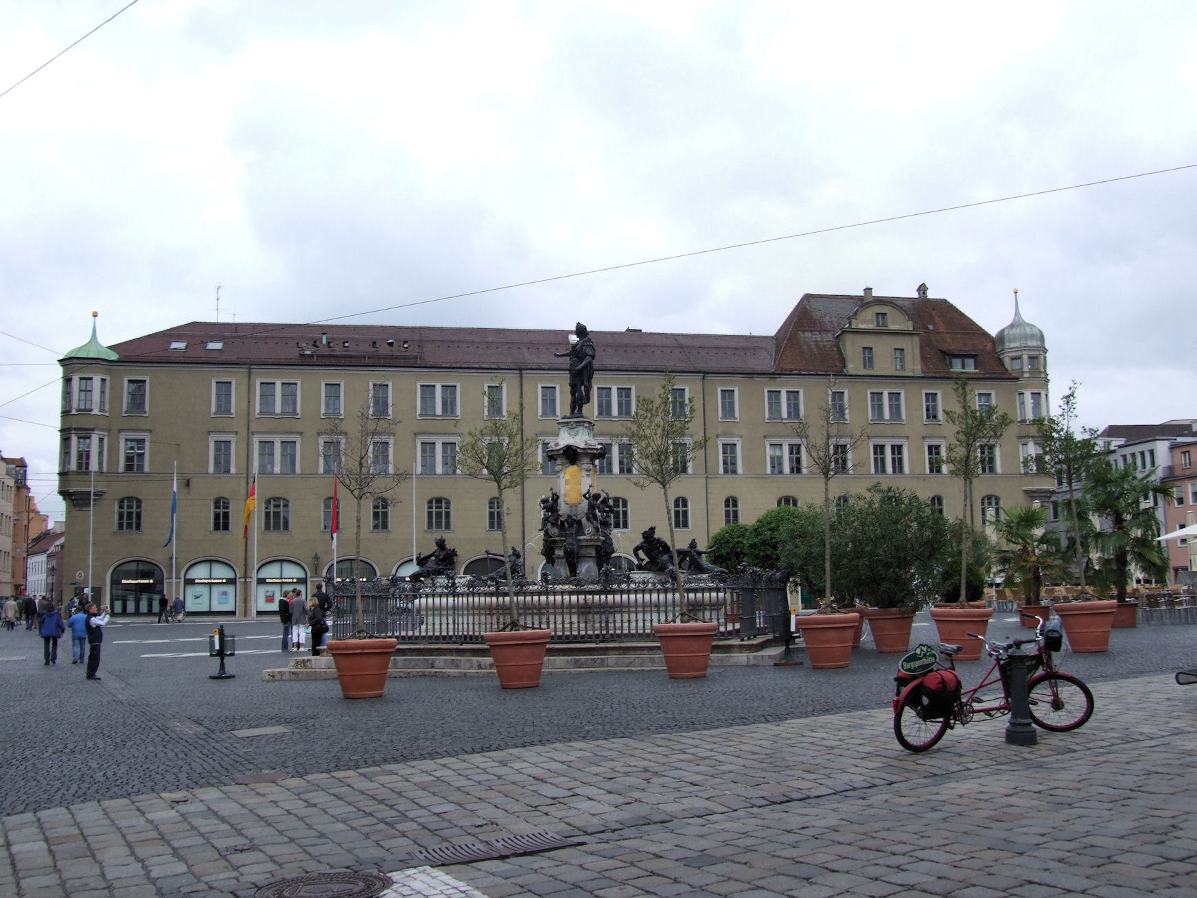 two people on bikes are by a fountain with an elephant statue