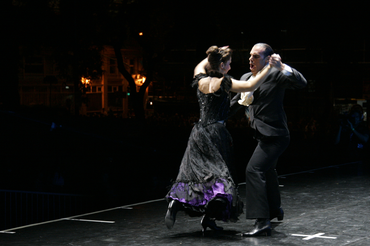 the man and woman are dancing on stage at night