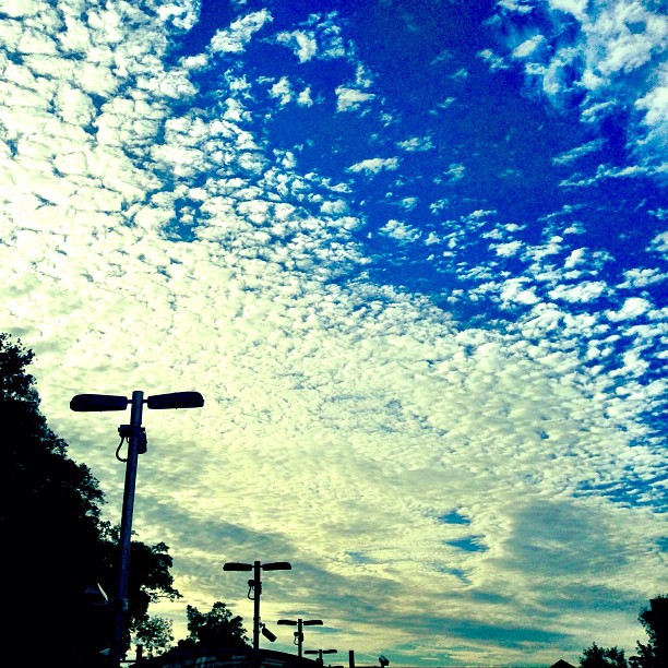 an image of a street sign under some clouds