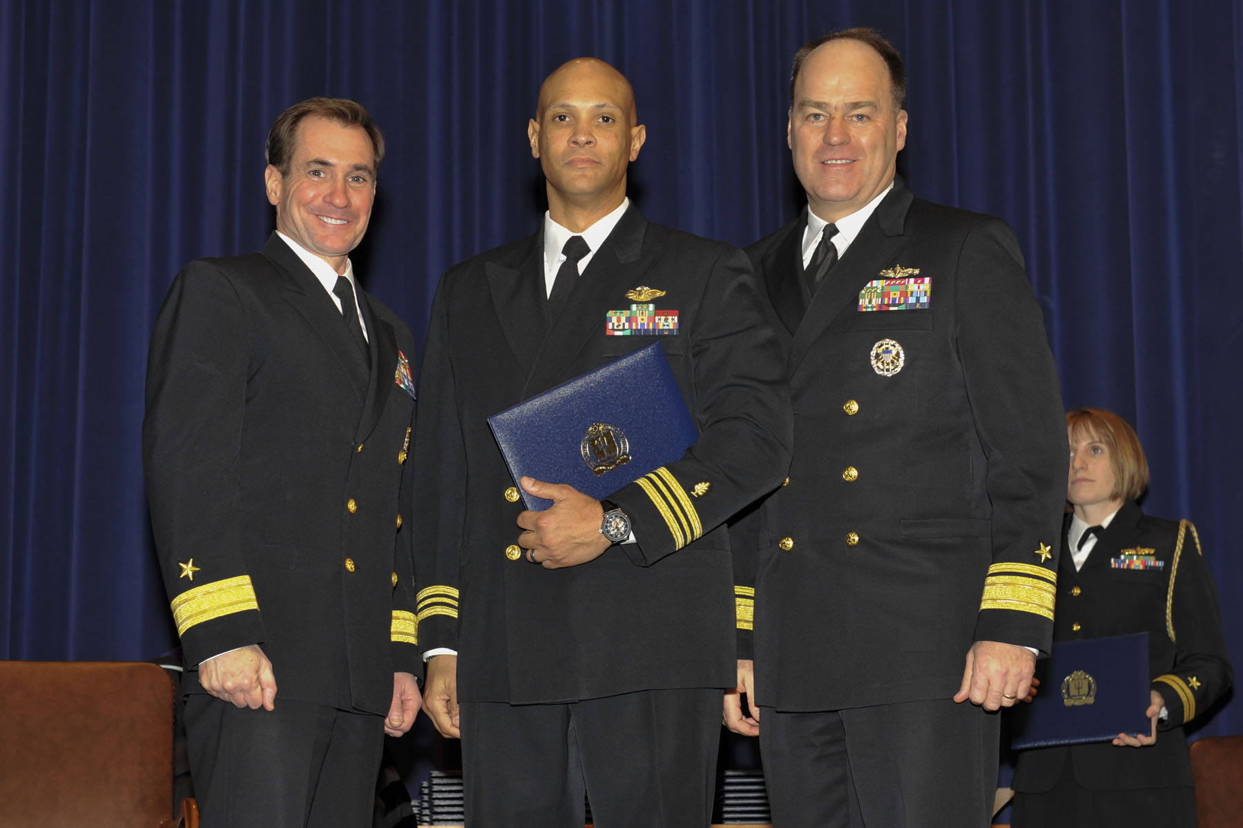 four men in navy uniforms posing for a po