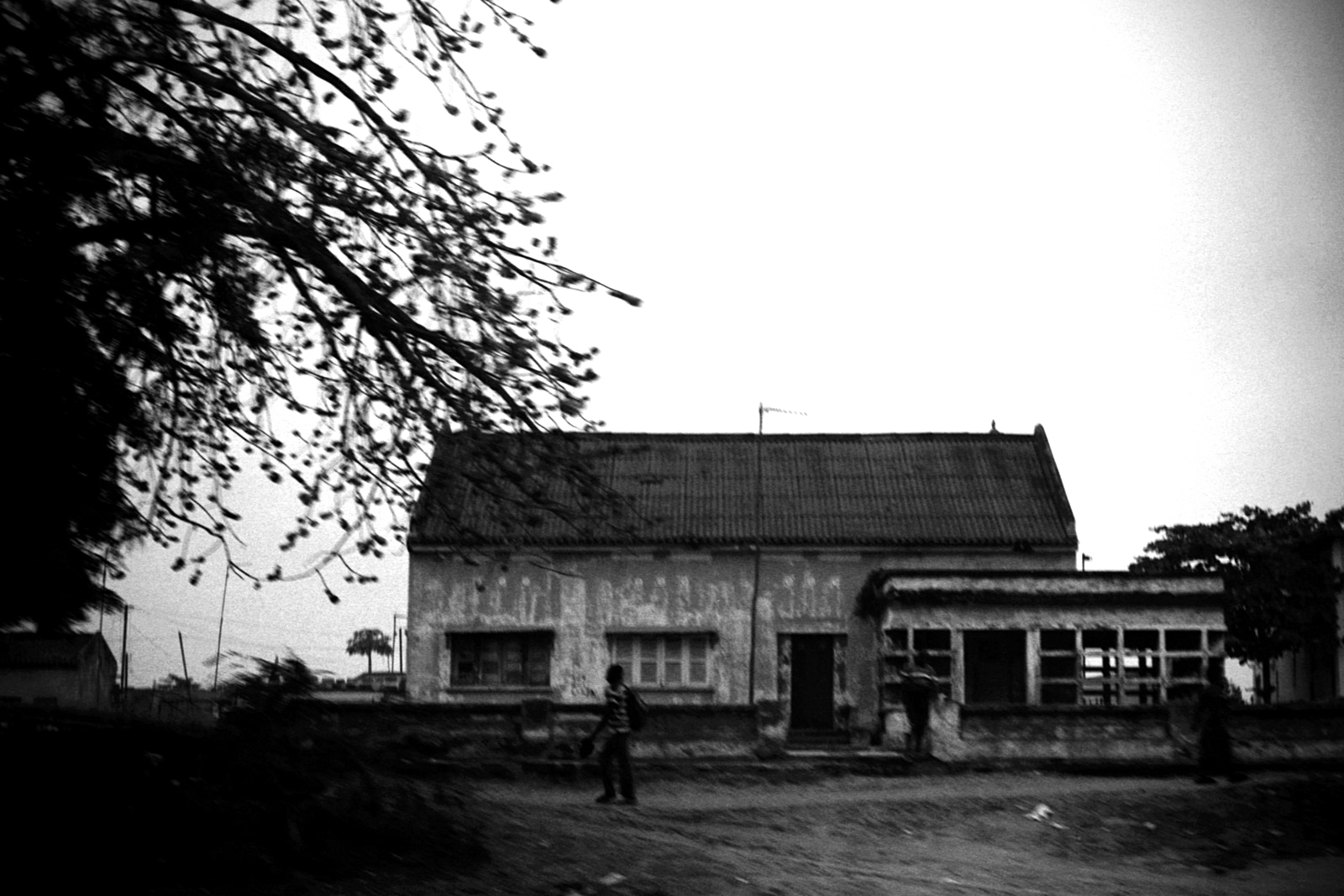 black and white po of a house with two people walking out front