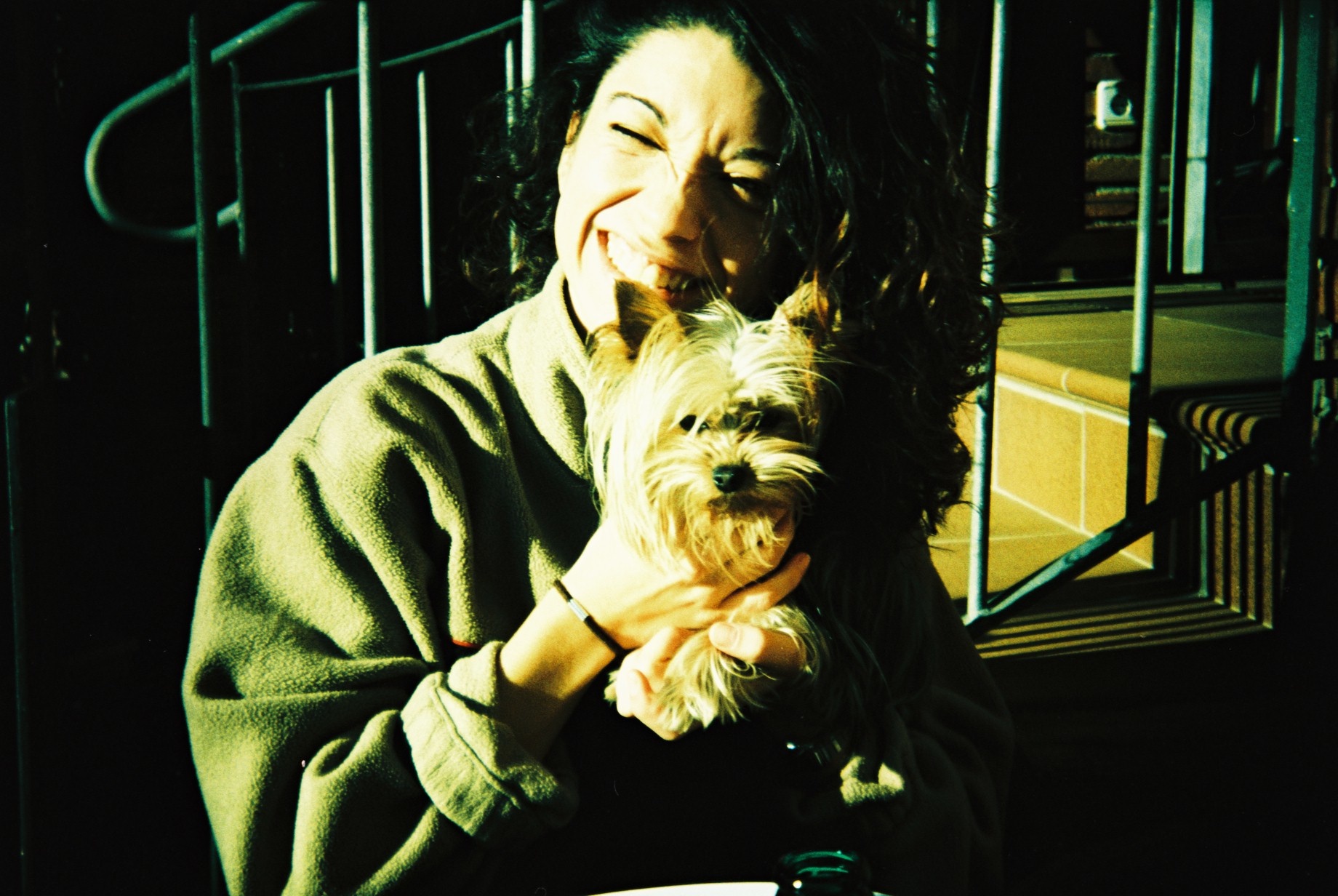 a woman holding her dog while sitting at the table