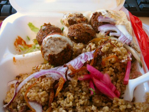a white container with rice, meat and vegetables in it