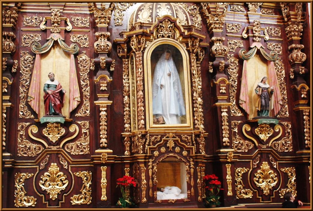 the inside of a golden church has statues in it