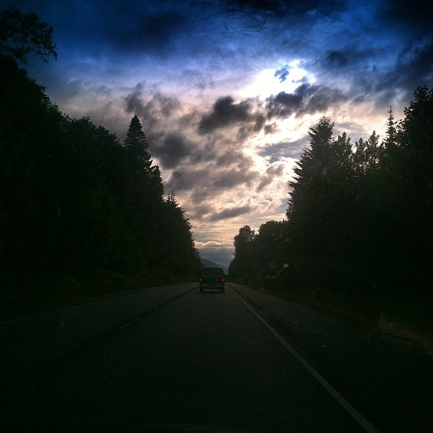 a view from a car on a dark road with a sky