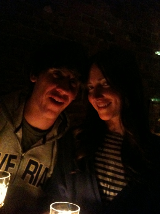 two people sitting together at a table with drinks