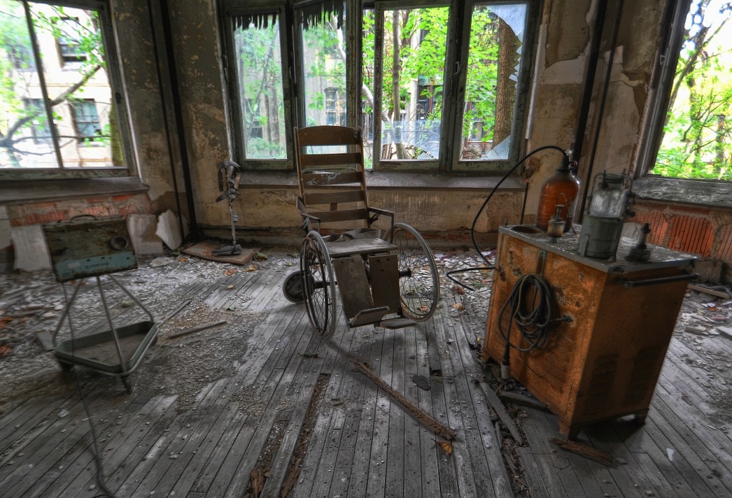 a room with an old bike, a box and two rusty boxes on the floor