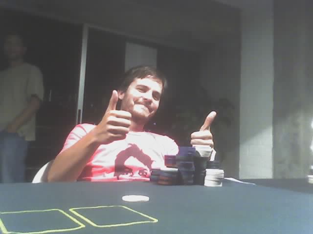 a man giving a thumbs up sitting at a table with casino chips
