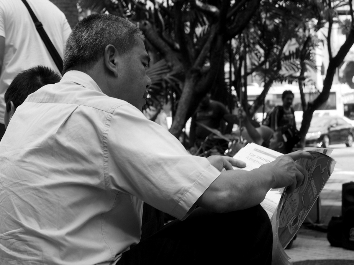 a man is reading a book while another person looks on