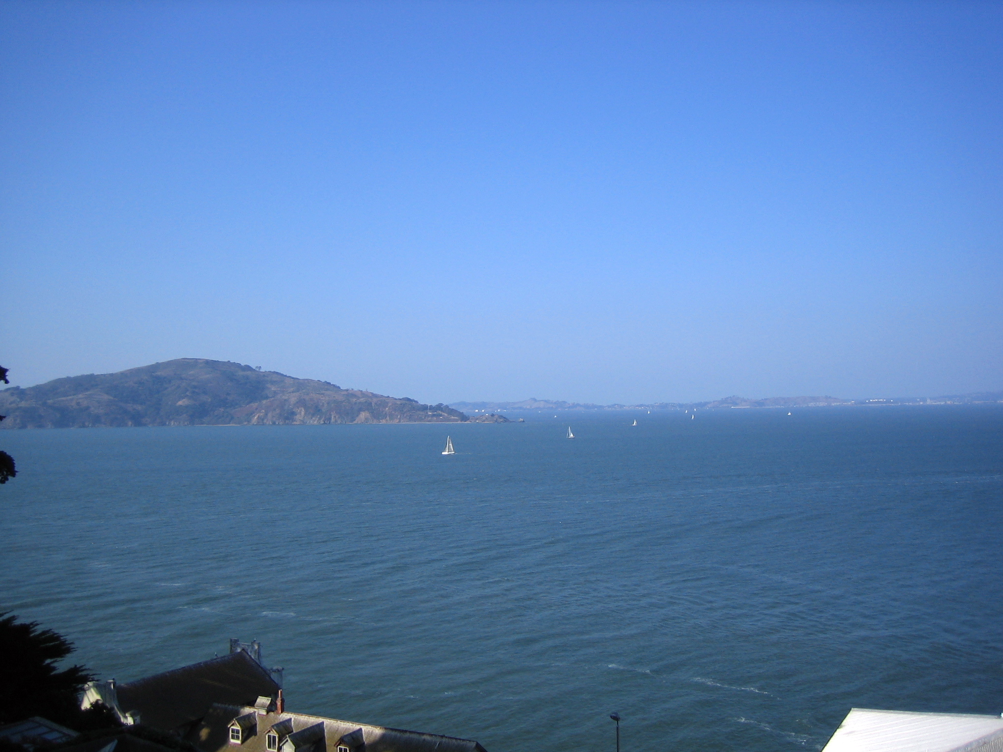 a view of water and hills under a clear blue sky