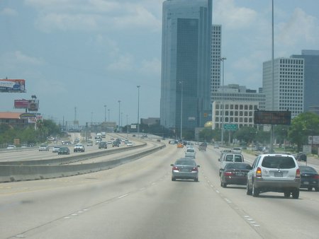 two lanes of traffic driving near tall buildings