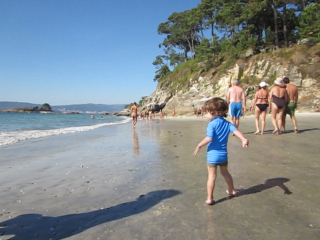 a little boy tossing a ball on the beach