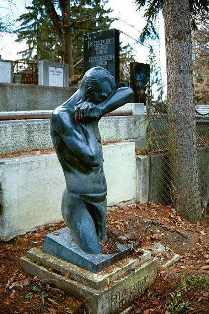an odd statue sits in a cemetery area