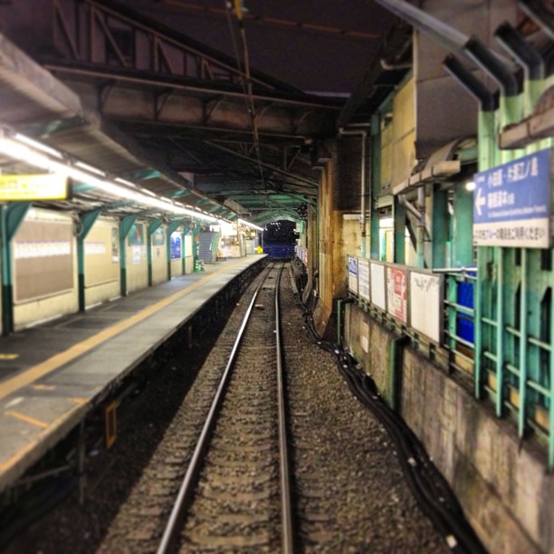 a train traveling down tracks next to a station