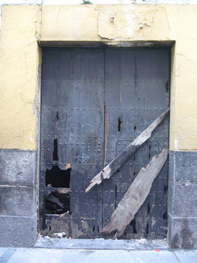 a door to an old house that has been torn open