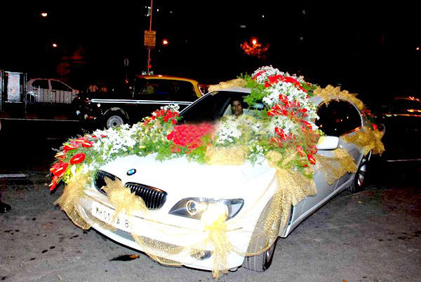 flowers are in a car that is decorated with gold and red ribbons