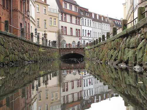 buildings and a canal with a bridge going into it