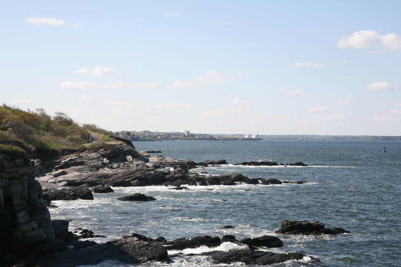 rocky shore line with several small boats in the water