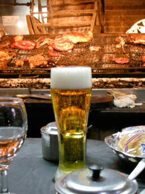 a plate of food and two glasses with beer on the table