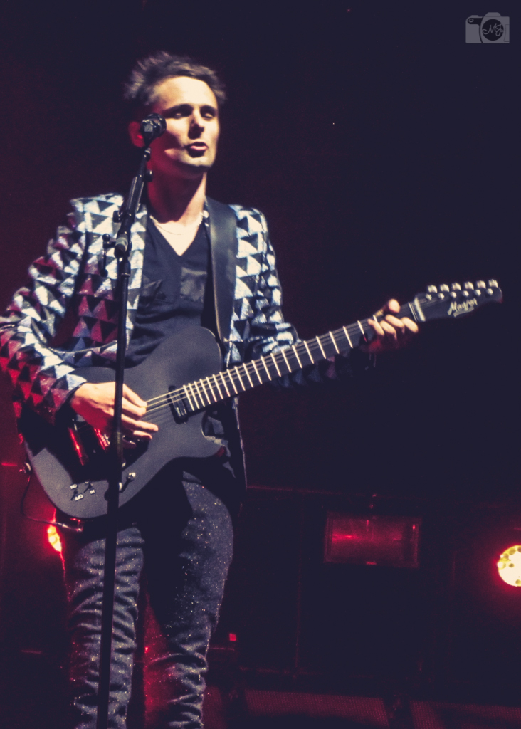 a man playing guitar in front of a microphone